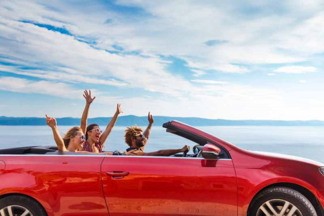 Group,Of,Happy,Young,People,Waving,From,The,Red,Convertible.